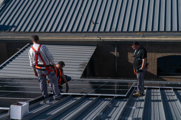 Fotografía de operarios instalando la planta fotovoltaica de Las Naves en el techo de la sede