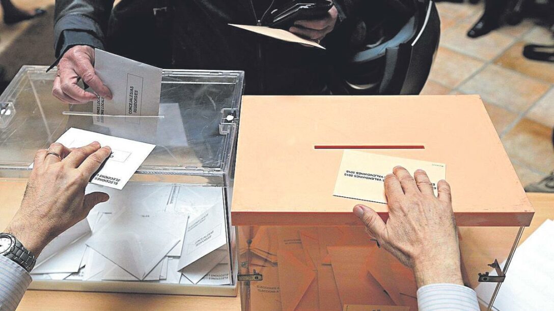 Fotografía de dos urnas de las elecciones con persona introduciendo su voto