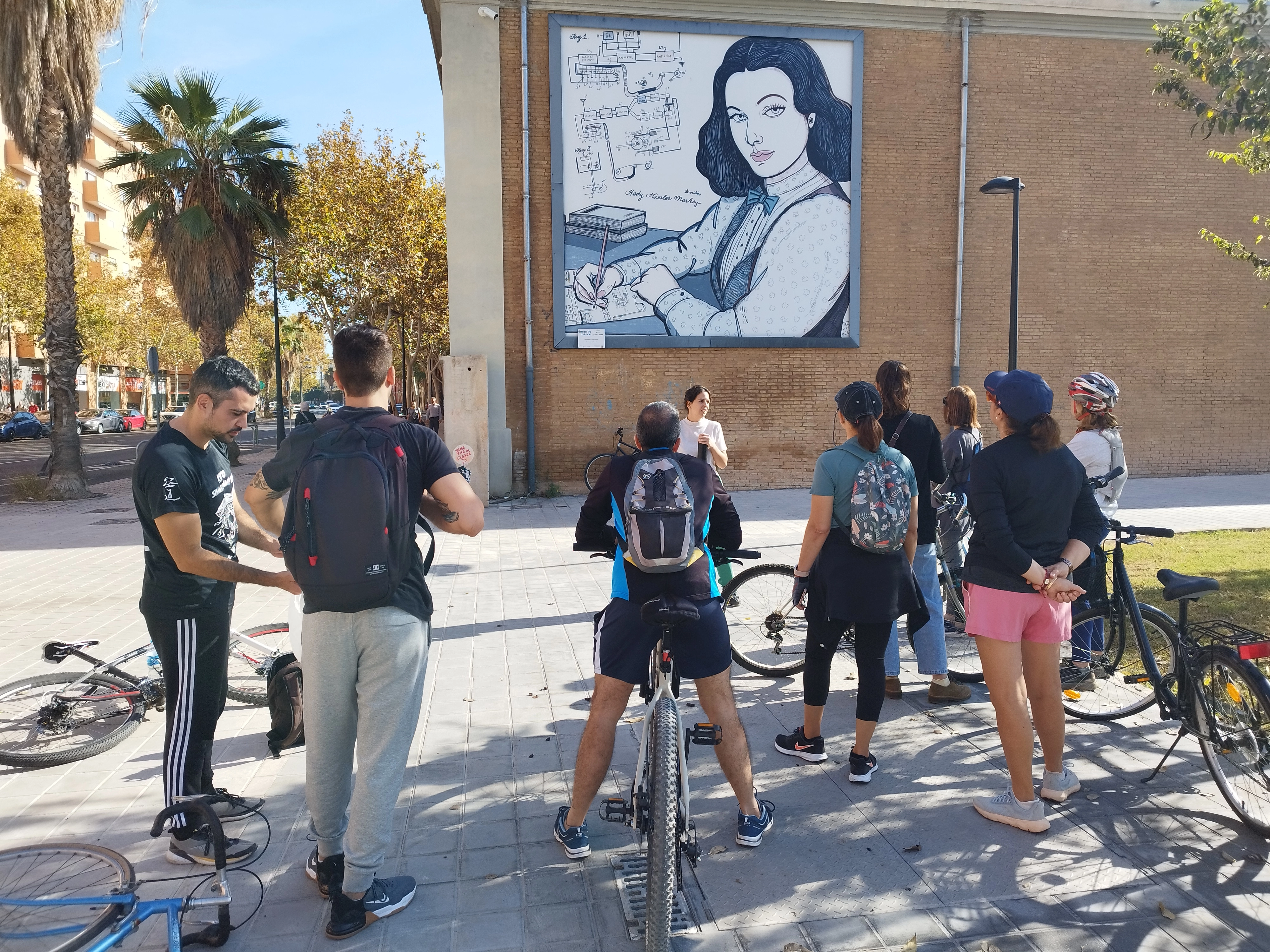 Fotografia dels participants a Pedaletjant amb Dones de Ciència davant d'un dels murals