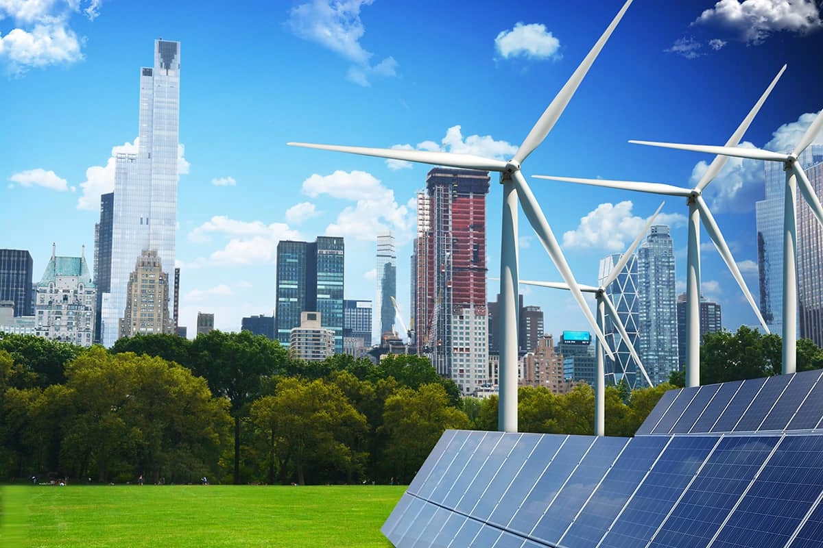 Fotocomposició d'una gran ciutat amb àrbres, generadors d'energia eòlica i plaques fotovoltaiques